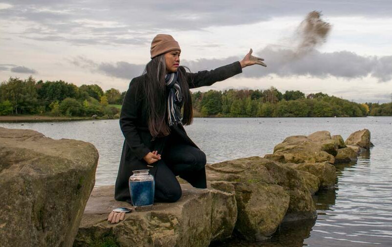 mulher jogando cinzas da cremação ao mar
