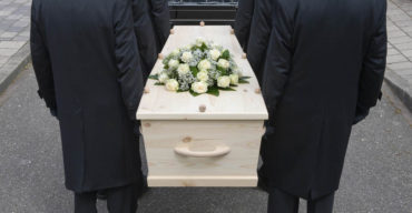 Pessoas segurando caixão saiba como funciona um plano funerário