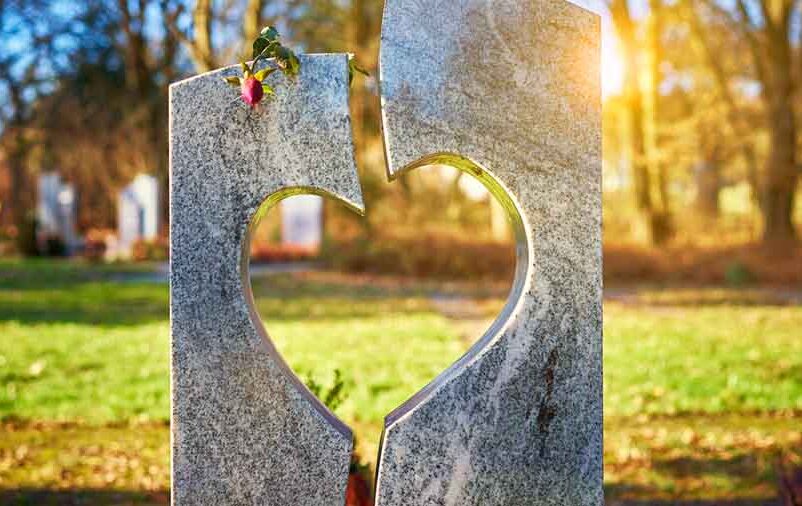 Cemitério jardim com uma pedra cortada em forma de coração em primeiro plano