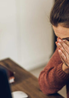 Mulher emocionada participa de um velório online para se despedir de um ente querido.