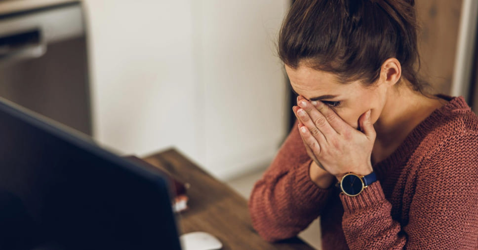 Mulher emocionada participa de um velório online para se despedir de um ente querido.