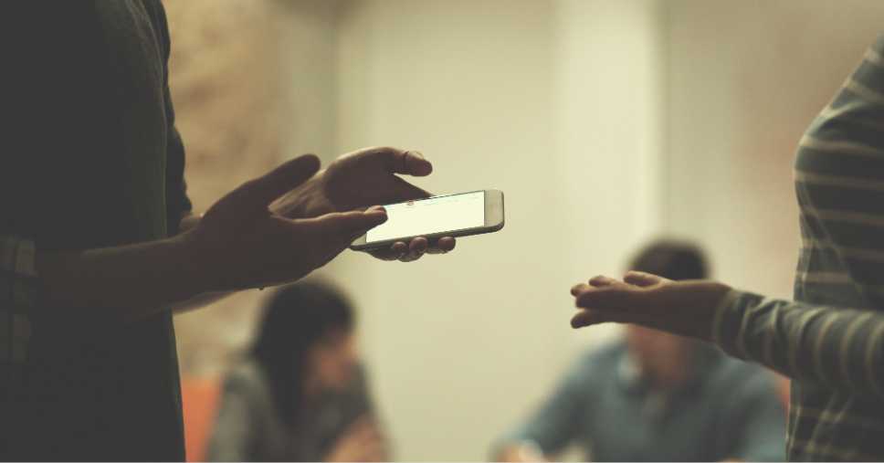 Pessoas usando o celular para saber o que fazer com as redes sociais de quem faleceu
