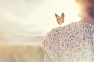 borboleta pousada no ombro de uma mulher